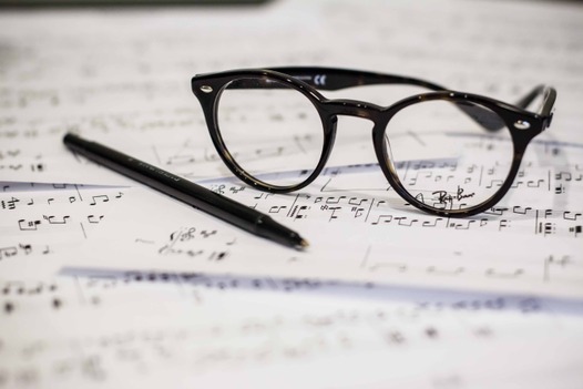 A close-up of a pair of frames atop sheet music